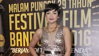 Ia tampak mengekspos dadanya lewat dress berbelahan rendah dengan hiasan kalung berlian dan gelang emas di tangannya. Pool/Noel/detikFoto.
