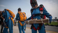 Persiapannya maksimal dan aksi dari mereka sangat menghibur penonton. Korea Utara ternyata punya wanita yang handal terjun payung juga! (Ed Jones/AFP)