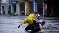 Akibat angin kencang, seorang pengendara motor nampak kehilangan kendali. REUTERS/Tyrone Siu.