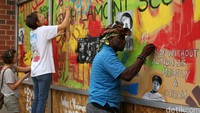 Beberapa seniman sepakat untuk menghiasi jendela hotel yang rusak dengan karya seni berupa mural. REUTERS/Mike Blake.