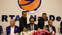Petugas menuang air minum ke gelas Ketua Umum Surya Paloh (tengah) yang diapit kader Partai NasDem yang juga Menteri Perdagangan Enggartiasto Lukito (kiri) dan Ketua Fraksi Partai NasDem Victor Laiskodat.