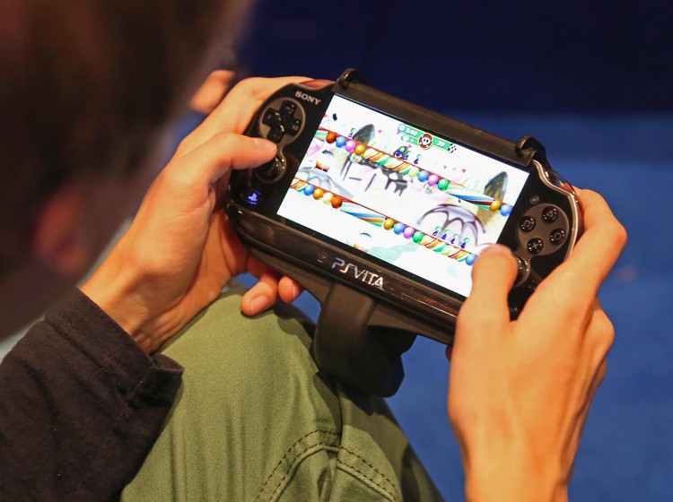 PlayStation Vita COLOGNE, GERMANY - AUGUST 22: A gaming enthusiast tries out a Sony Playstation Vita game at the Gamescom 2013 gaming trade air on August 22, 2013 in Cologne, Germany. Gamescom is the worlds largest trade fair for digital gaming and will be open to the public from August 22-25. (Photo by Juergen Schwarz/Getty Images)