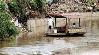 Perahu menyeberangkan warga dari Bukit Duri ke Kampung Pulo.