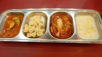 Sambil menunggu pesanan, ada banchan (side dish) berisi makaroni salad, kimchi, cream corn dan oi muchim (salad mentimun) dengan porsi mini.