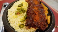 Rolling Cheese Beef Ribs yang jadi andalan berisi US Ribs dengan parutan keju mozzarella yang cukup royal. Toppingnya ada jalapeno, pipilan jagung dan taburan cabai bubuk. Di dekat iga terlihat beberapa potong potato wedges.