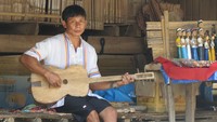Seorang pria Karen bermain gitar. Kebanyakan pria di desa ini bekerja sebagai pawang gajah di Maesa Elephant Camp (Fitraya.detikTravel)