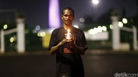 Ayah dari Yufrinda Selan, Metusalak Selan menyalakan lilin.