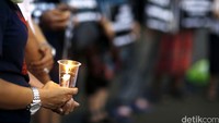 Keluarga Besar Buruh Migran Indonesia (Kabar Bumi) dan Jaringan Buruh Migran Indonesia (JBMI) menyalakan lilin di depan Istana Negara.