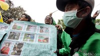Salah satu driver Go-Jek nampak memamerkan poster berisi foto-foto sesama driver yang terlibat kecelakaan bahkan meninggal dunia.
