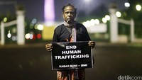 Ayah Dolfina Abuk, Petrus Bouk membentangkan poster bertuliskan End Human Trafficking.