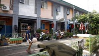 Seorang anak bermain bola di depan rumahnya di Kampung Deret Petogogan.