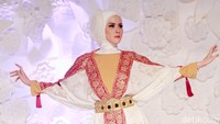 Angel tampil dengan busana muslim bergaya batwing berwarna putih dengan aksen merah kala tampil di sebuah acara. Pool/Gus Mun/detikFoto.