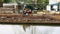 Pemotor melintasi pinggir sungai Kalimalang.