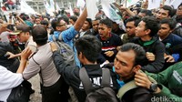 Demonstran berusaha menerobos barikade polisi.