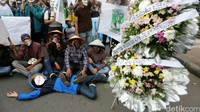 Para mahasiswa juga membawa karangan bunga duka cita.
