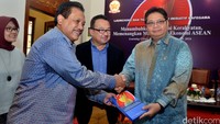 Menteri Perindustrian Airlangga Hartarto (kanan) menerima buku Ekonomi Kerakyatan dari Ketua KAFEGAMA Sapto Amal Damandari (kedua kiri) disaksikan Ketua Tim Penyusun Hendri Saparini (kiri) dan Guru Besar FE UI Rhenald Kasali.