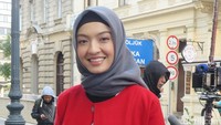 Aktris berusia 31 tahun itu tampak mengenakan hijab abu-abu, coat merah, blazer putih serta rok hitam.
