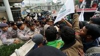 Polisi berupaya menenangkan massa.
