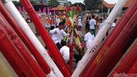 Sambil menunggu acara dimulai, beberapa bocah mengisi kebosanan dengan berkejar-kejaran. Egrang disusun rapi berbentuk seperti piramid.