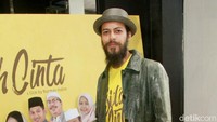 Ia tampil dengan fedora hat, jaket bermotif kulit ular, kaus dengan jeans dan boots. Pool/Gus Mun/detikFoto.