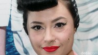 Ia tampil dengan gaya rambut berponi andalannya serta bandana dan lipstik merah. Pool/Gus Mun/detikFoto.