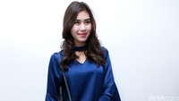 Ia tampak mengenakan atasan biru yang dipadukan dengan jeans serta sepatu sandal berwarna abu-abu. Pool/Palevi S/detikFoto.