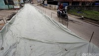 Seorang pengendara sepeda motor melintas di proyek pembetonan jalan di Desa Bojongkulur.