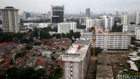 Pembangunan gedung bertingkat bersebelahan dengan pemukiman padat penduduk serta gedung perkantoran.