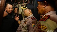 Di depan pintu, Satpol PP memasang surat pemberitahuan penyegelan Milles. Ada personel polisi yang mengamankan penyegelan ini.