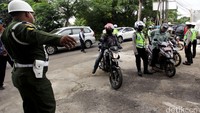 Personel gabungan memberhentikan semua kendaraan bermotor yang melintas untuk diperiksa kelengkapan suratnya.