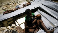 Warga tidur beralaskan lembaran seng di sebuah sekolahan yang rusak akibat topan. Carlos Garcia Rawlins/Reuters/detikFoto.