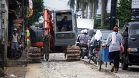 Alat berat sedang memecahkan coran yang akan diganti.