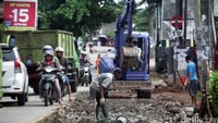 Alat berat sedang meratakan jalan untuk dicor.
