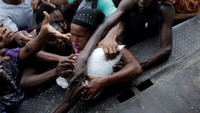 Wanita dan pria ikut berebut bantuan makanan. REUTERS/Andres Martinez Casares.