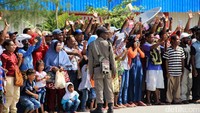 Warga melambaikan tangan saat pesawat kepresidenan mendarat di Bandara Nop Goliat Dekai.