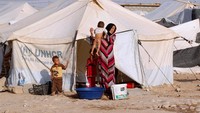 Seorang ibu terlihat memandikan anaknya di kamp pengungsian di wilayah Daquq, Irak.