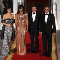 Saat menerima kedatangan PM Italia Matteo Renzi 2016 lalu, Michelle Obama memilih gaun rosegold Atelier Versace yang mengekspos bahunya. Foto: Dok. Getty Images