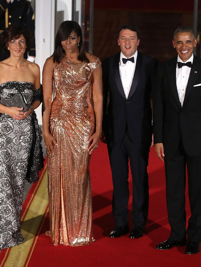 Saat menerima kedatangan PM Italia Matteo Renzi 2016 lalu, Michelle Obama memilih gaun rosegold Atelier Versace yang mengekspos bahunya. Foto: Dok. Getty Images
