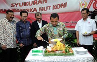 Ketua Umum KONI Pusat Tono Suratman memotong tumpeng.