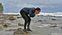 Foto: Jokowi kemudian berdiri di sebuah gundukan batu. Tak lama kemudian, dia berjongkok dan membasuh mukanya dengan air laut. Fotografer Kepresidenan Agus Suparto