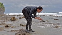 Jokowi kemudian berdiri di sebuah gundukan batu. Tak lama kemudian, dia berjongkok dan membasuh mukanya dengan air laut. 