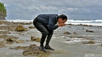 Foto: Jokowi yang mengenakan jaket berwarna biru itu kemudian turun. Dia berjalan di pinggir pantai yang dipenuhi bebatuan. Fotografer Kepresidenan Agus Suparto