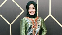 Pelantun Away itu tampil dengan hijab hitam, dress hijau bercorak abstrak dan heels hitam. Pool/Palevi S/detikFoto.