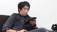 Ia sibuk memainkan ponselnya. Pool/Ismail.