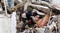 Tim Gegana memeriksa beberapa tabung gas yang tertimbun reruntuhan bangunan.