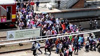 Penumpang bergegas di Stasiun Tanah Abang dengan melintasi rel.