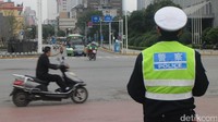 Seorang pengendara nekat tak mengenakan helm di depan polisi yang tengah berjaga di wilayah Hunan, Changsha, China.