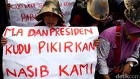Warga demo sambil membawa spanduk dan poster.