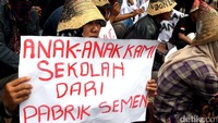 Sambil berorasi, warga membentangkan poster mendukung tetap berdirinya pabrik semen di Rembang, Jawa Tengah.