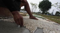 PTRA juga dilengkapan area refleksi. Tampak seorang pekerja memasang bebatuan kecil untuk refleksi kaki.